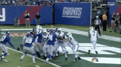 Football Game Under Giants Sign GIF