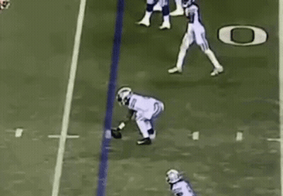 Football Player Catching Ball While Being Tackled GIF