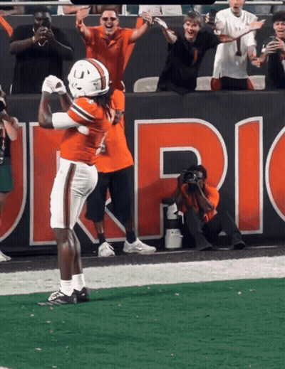 Football Player Celebrating Touchdown Under Uric Banner GIF