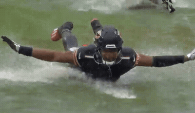 Football Player Flying Through Air Holding Ball GIF