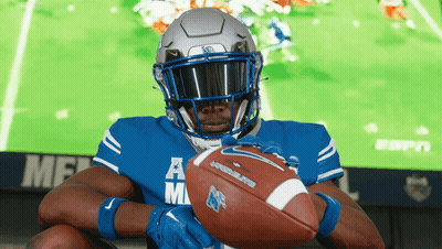 Football Player Holding Ball In Front Of ESPN Screen GIF