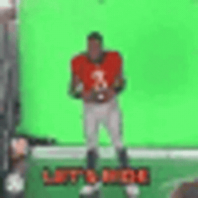 Football Player Holding Football In Front Of Green Screen GIF