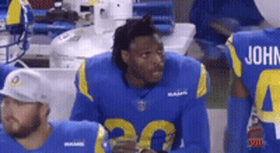 Football Player In Blue And Yellow Uniform Sitting On Sidelines GIF