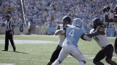 Football Player In Blue Jersey Number 4 Tackled By Referee GIF