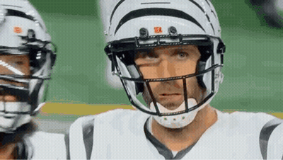 Football Player in Helmet and White Jersey Looking at Camera