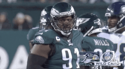 Football Player In Helmet Standing In Front Of Group GIF