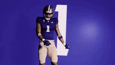Football Player In Purple Uniform Dancing In Front Of Blue Wall Number 1 GIF