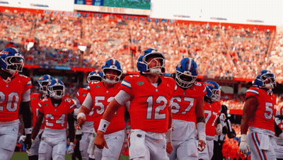 Football Player in Red Jersey Number 12 With Teammates