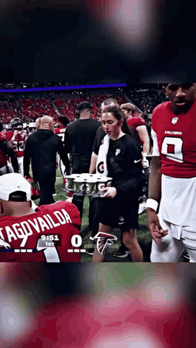 Football Player in Tagovailoa Jersey Holding Drinks