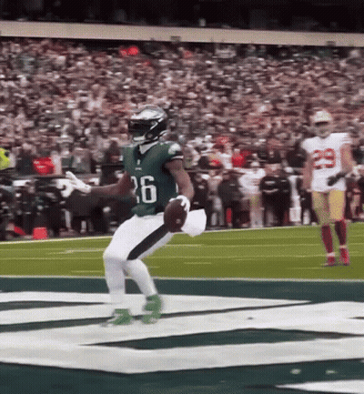 Football Player Jumping Holding Ball On Field GIF