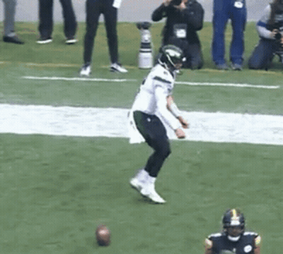 Football Player Kicking Ball While Another Watches GIF