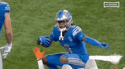 Football Player Kneeling While Another Holds Football GIF