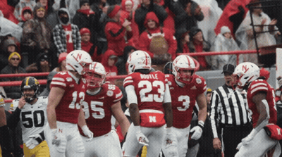 Football Player Number 23 Surrounded By Teammates GIF