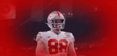 Football Player Number 23 Surrounded By Teammates GIF