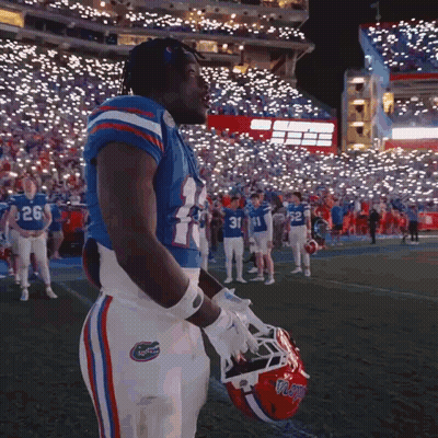 Football Player Number 24 Holding Helmet In Front Of Crowd GIF