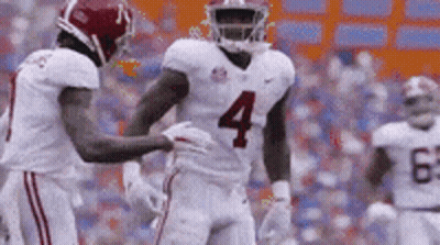 Football Player Number 4 Being Helped By Teammate GIF