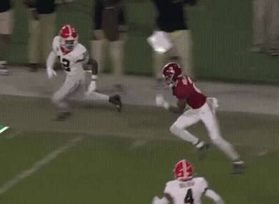 Football Player Number 4 Runs Past Red Jersey GIF