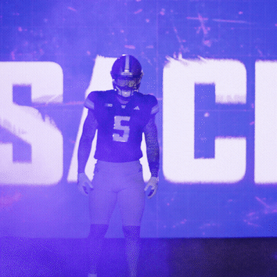 Football Player Number 5 Standing In Front Of Large Screen GIF