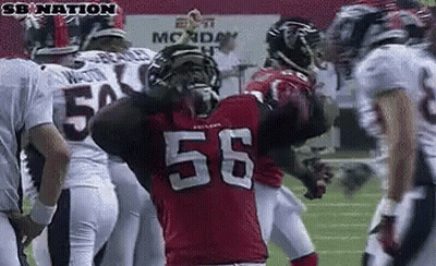 Football Player Number 56 Surrounded by Players