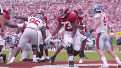 Football Player Number 73 Surrounded By Players GIF