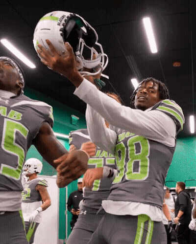 Football Player Number 98 Holding Helmet Above Head GIF