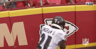 Football Player Running In Front Of NFL Logo Wall GIF