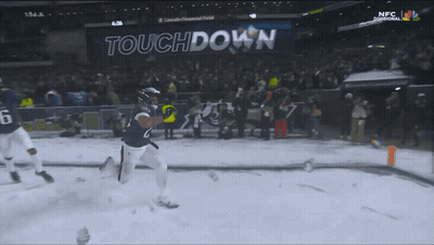 Football Player Running In Snow In Front Of Touchdown Sign GIF