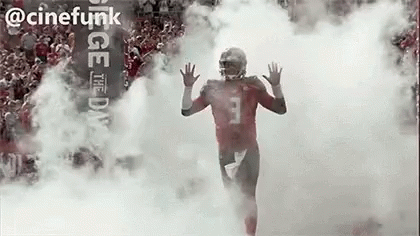 Football Player Running Through Cloud Of Smoke GIF