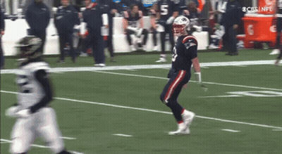 Football Player Running While Another Watches GIF