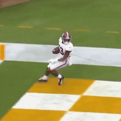 Football Player Running With Ball On Checkered Field GIF