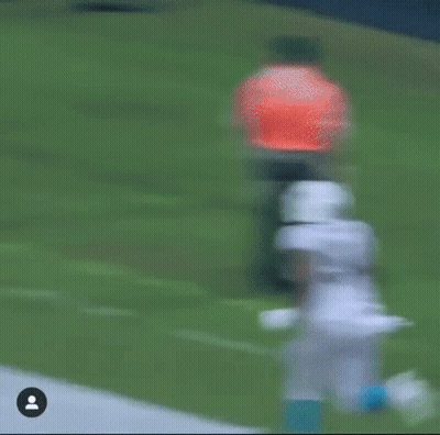Football Player Running With Referee Behind