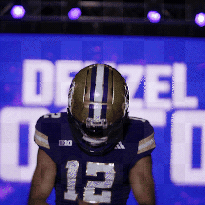 Football Player Standing In Front Of Dezel Sign GIF