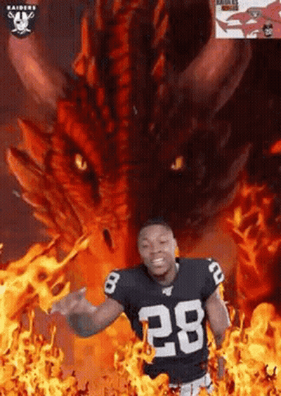 Football Player Standing In Front Of Dragon Surrounded By Flames GIF