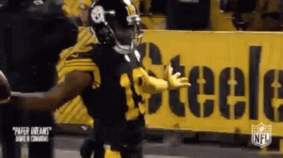 Football Player Standing In Front Of Yellow Sign GIF