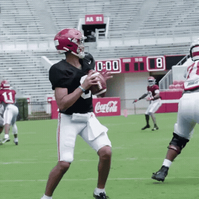 Football Player Throwing Ball In Front Of Coca-Cola Sign GIF