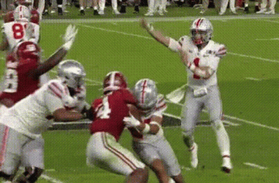 Football Player Throwing Pass While Being Tackled GIF