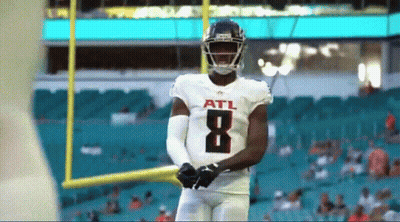 Football Player Throws Ball On Field With Crowd GIF