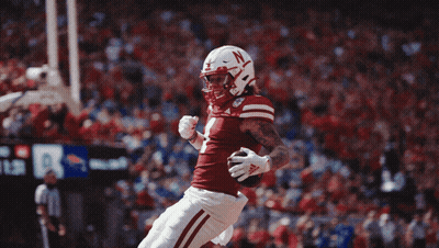 Football Player With N On Helmet Jumping GIF