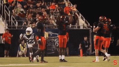 Football Players Celebrating Touchdown Under Banner Saying Aping World GIF