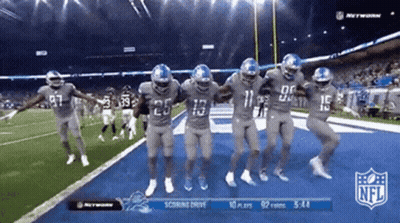 Football Players Dancing In Front Of NFL Scoreboard GIF