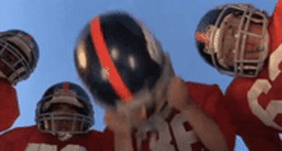 Football Players Holding Helmets Up GIF
