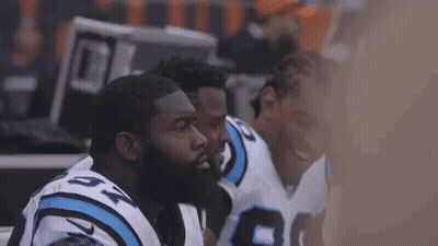 Football Players Huddle On Sidelines GIF