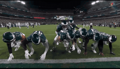 Football Players Huddled In Stadium GIF