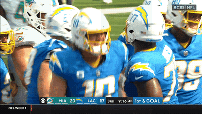 Football Players Huddled On Field GIF