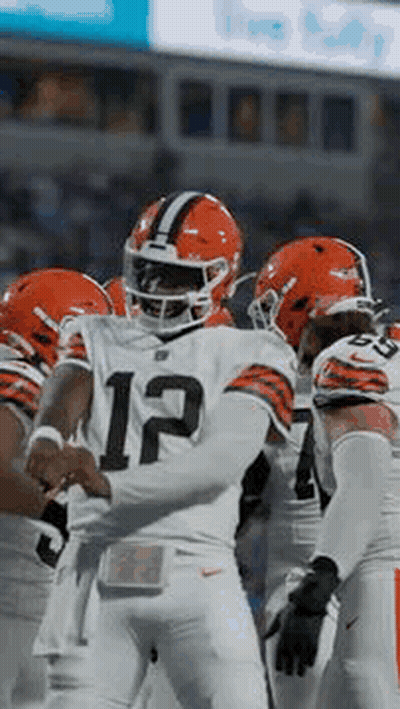 Football Players Huddled On Field GIF
