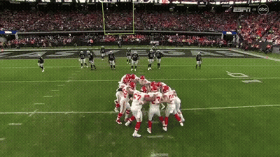 Football Players Huddled Together On Field GIF