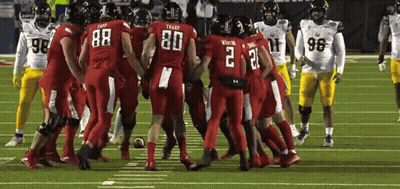 Football Players Huddled Together On Field GIF