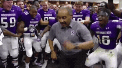 Football Players In Purple Uniforms Dancing With Man In Grey Shirt GIF