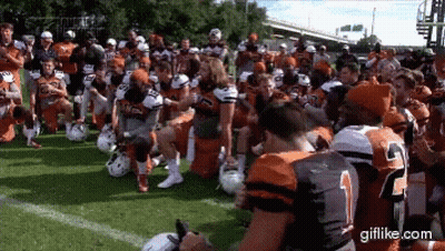 Football Players Kneeling On Field With Number 2 Jersey GIF