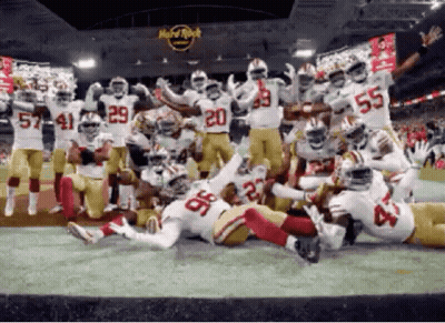 Football Players Posing In Front Of Hard Rock Cafe GIF